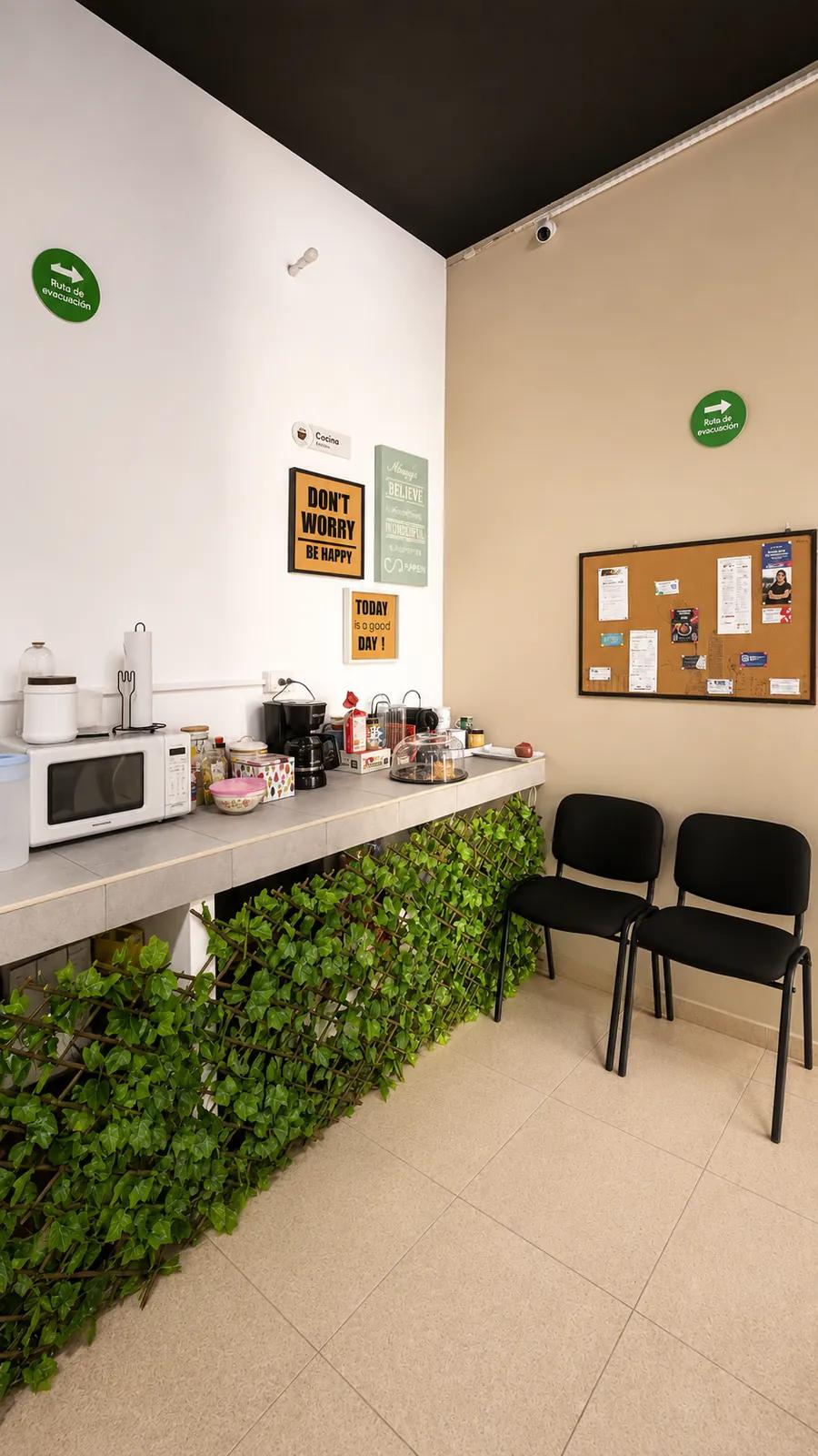 Cocina del coworking con microondas, cafeteras y barra de cortesía para los usuarios