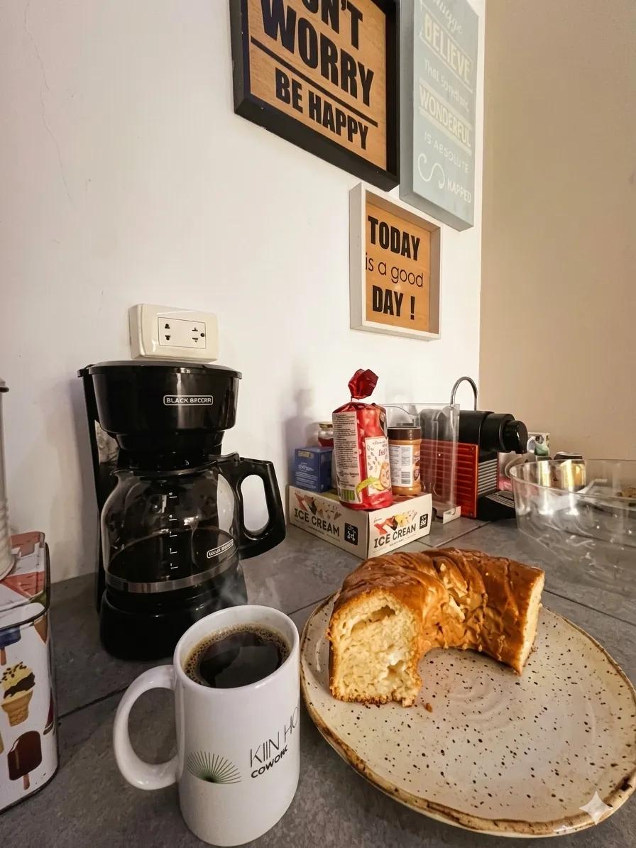 Taza de Kiin Hub Cowork con café recién hecho junto a pan dulce en la cocina del espacio